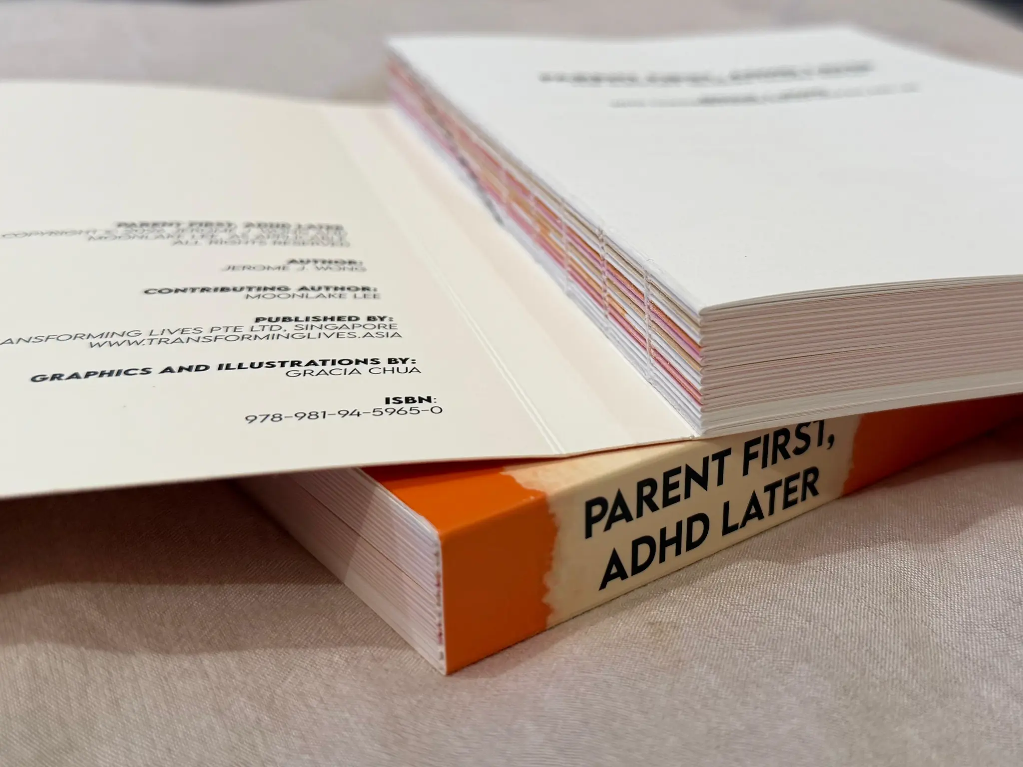 Swiss binding — two copies of the book showing the colourful page edges and spine
